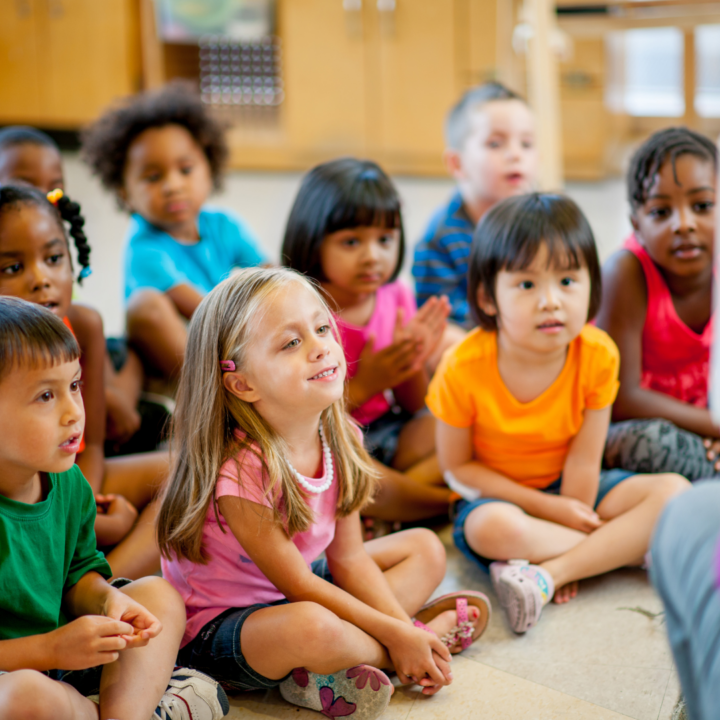 Small children sitting on the floor in a classroom
