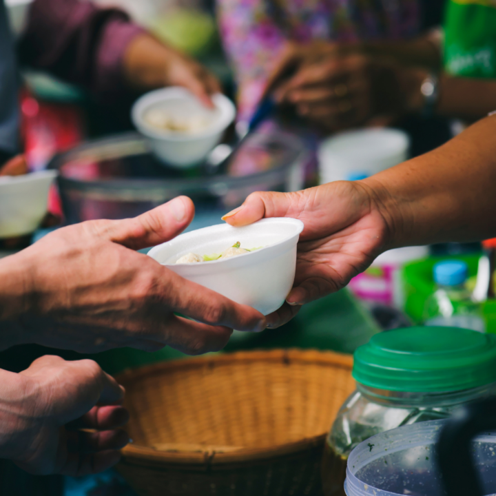 Hands handing over a donation bowl